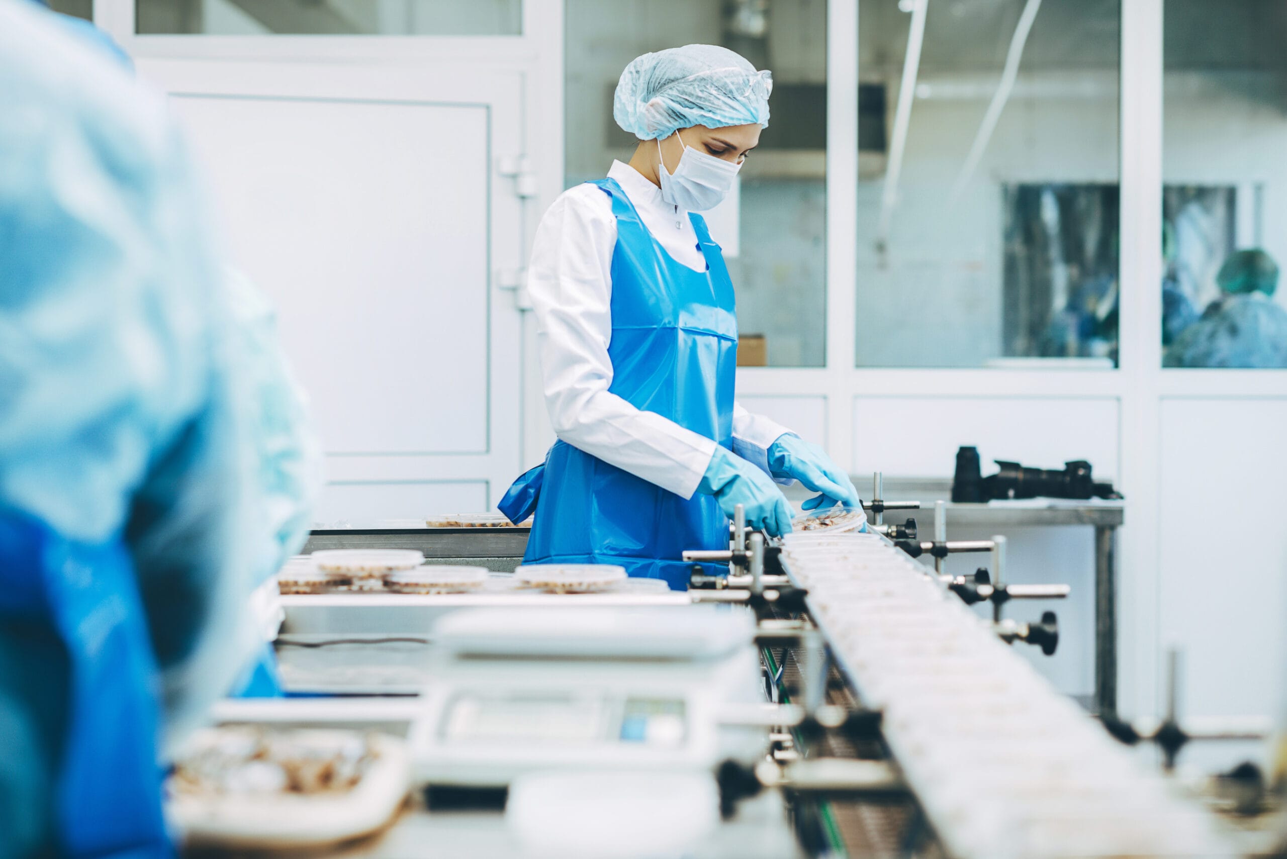 Arbeiter in einer Lebensmittelfabrik mit Hygienekleidung zum Mieten